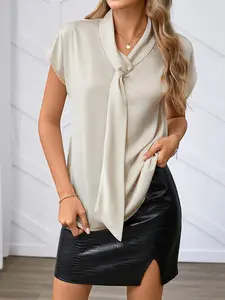 A lady's light peach-colored bow-necked short-sleeved shirt with an elegant style