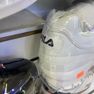 Fila Disruptor White Sneakers with Logo Detailing and Orange Accents