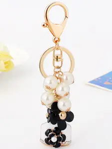Korean-style Chanel-inspired faux pearl camellia keychain pendant, fashionable and creative flower perfume bottle bag keychain