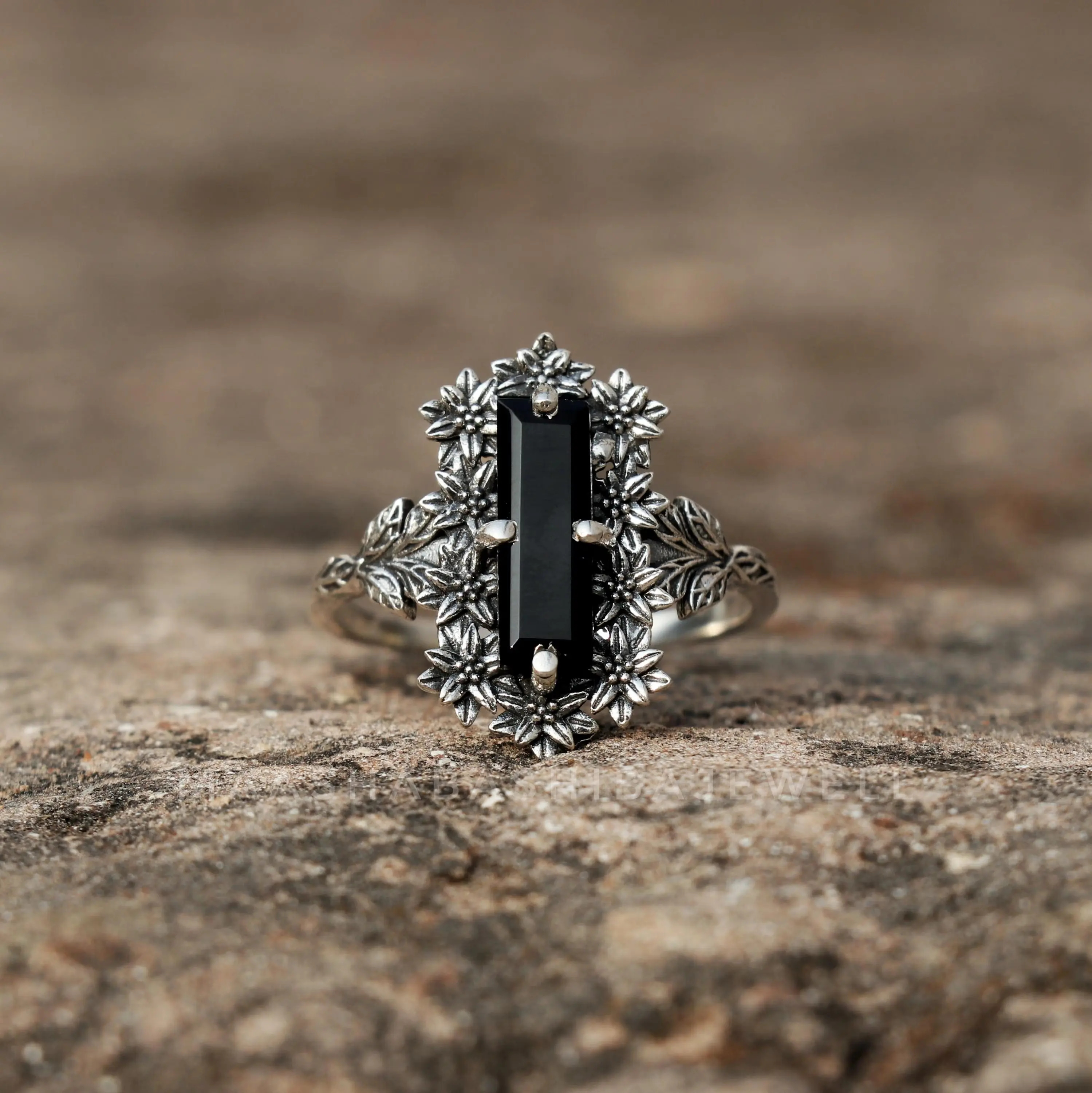 A vintage dark forest-inspired ring with a rich Victorian aesthetic, featuring a rectangular-cut black synthetic agate. The ring is adorned with three-dimensional floral reliefs, creating a unique bohemian-style piece.