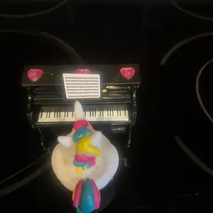 Unicorn rubber duck sitting at piano