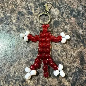 Red Beaded Keychain with White Beads, Featuring a Unique Design and a Metal Clasp for Easy Attachment