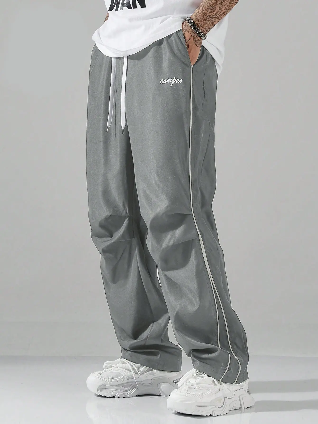 Single pack men’s drapey wide-leg casual pants featuring side line embroidery, a drawstring waist, and breathable ice silk fabric—ideal for summer campus commuting outfits.