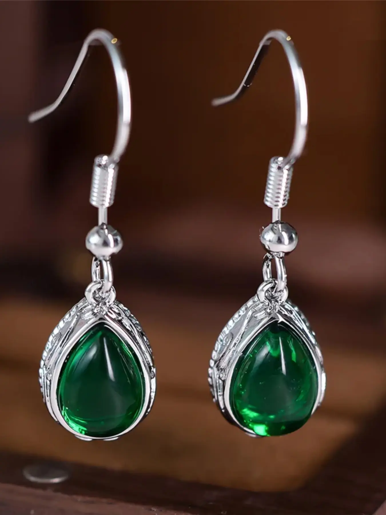 A pair of green oval-shaped dainty dangly earrings made of synthetic crystal zirconia, stylish and high-end, perfect for wearing during weddings and special occasions as a piece of women's jewelry, Fashion Jewelry Earrings