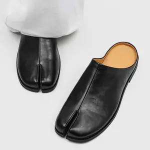 Men’s Black Genuine Leather Tabi Split-Toe Mule Loafers. Classic split tabi toe design paired with smooth cow leather delivers avant-garde minimalist vibe. Backless mule style enables effortless slip-on wear, slim sole maintains sleek silhouette