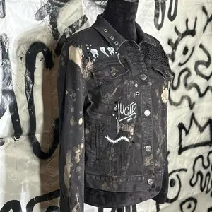 Handmade black acid washed denim jacket with hand-painted patchwork and lace cut out paneling.