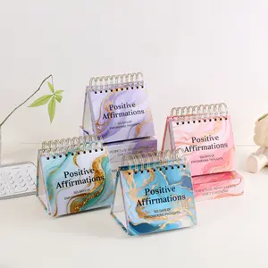 One Piece of a Desktop Calendar Featuring Empowering Thoughts And Positive Affirmations for Every Day of The Year. Has a Standing Flip Design with Inspirational Quotes And Colorful Inner Pages, Making It Suitable for Use at School, Home