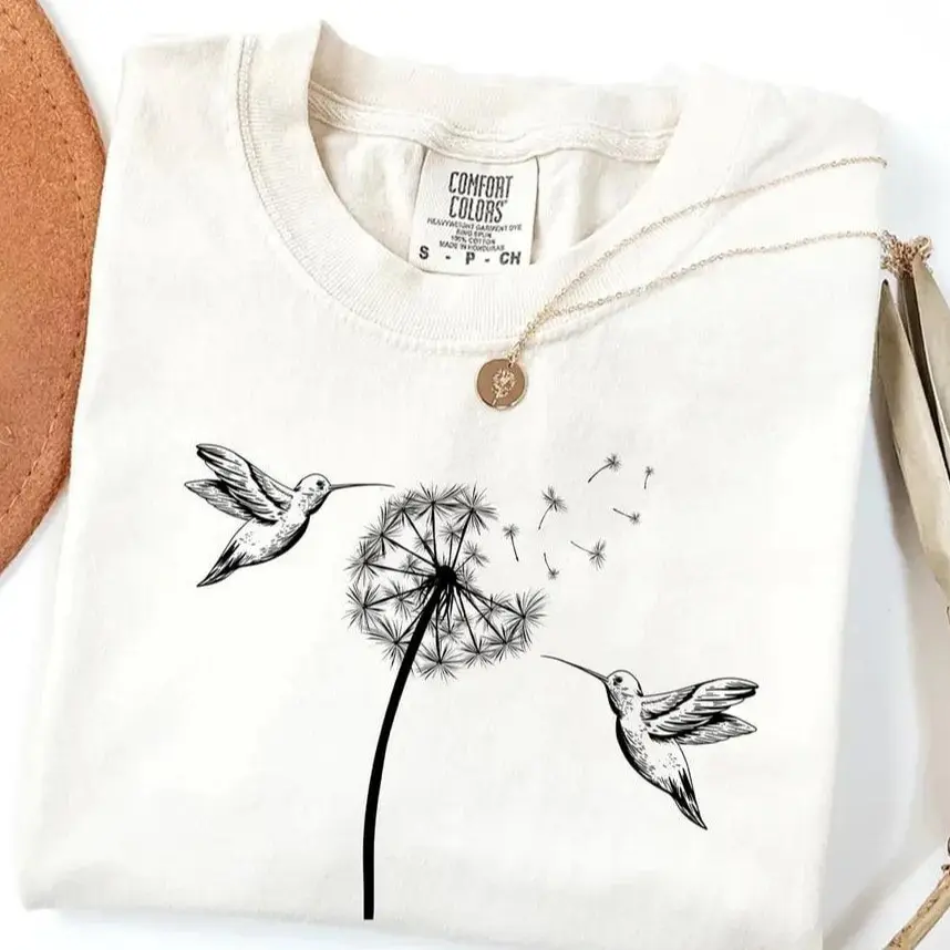 Comfort Colors Cute Dandelion Hummingbird T-Shirt featuring a delicate nature design, perfect for animal lovers, women, and a thoughtful gift idea.