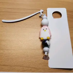 Beaded bookmark with pink penguin bead and smiling cloud charm