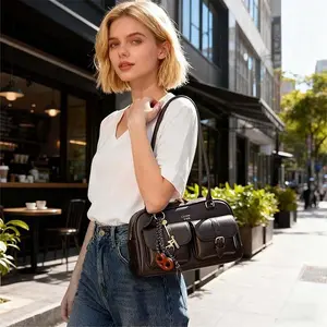 Vintage brown leather shoulder bag with an adorable teddy bear keychain, multiple pockets, stylish and casual, suitable for everyday wear and travel.