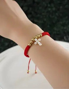 Handcrafted Adjustable Bracelet Woven with Red Thread and Beads Featuring Pearl Cross Charm for Cultural Significance and Protection