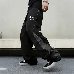 Men’s high-street style sweatpants with color-block panels and side stripes, tapered wide-leg or straight-leg cut, American retro cartoon print design, relaxed drape, available in multiple colors, lightweight casual pants for spring/summer.