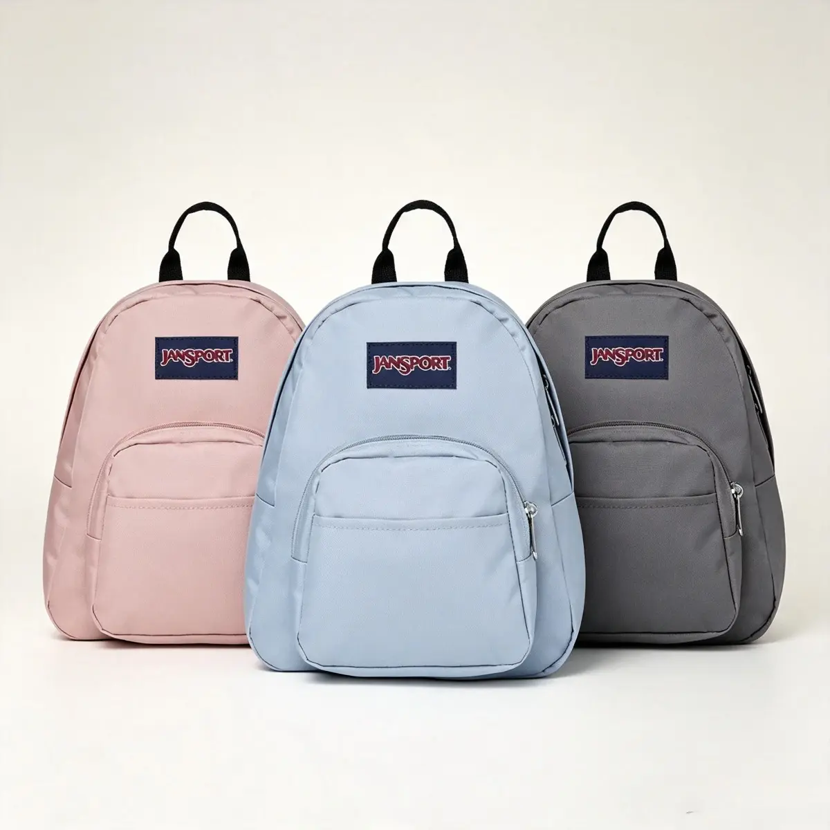 JanSport Half Pint Mini Backpack—A durable mini backpack with adjustable shoulder straps, a single main compartment, and a zippered pocket, in blue