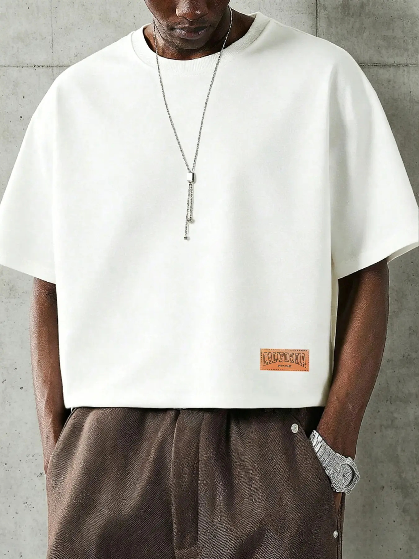 A cropped T-shirt, Fit T Shirt, Crewneck, Round neck, Menswear, Streetwear, featuring seamless batwing short sleeves and a leather-textured graphic, with minimalist casual aesthetic, perfect for occasions from vacations to everyday wear