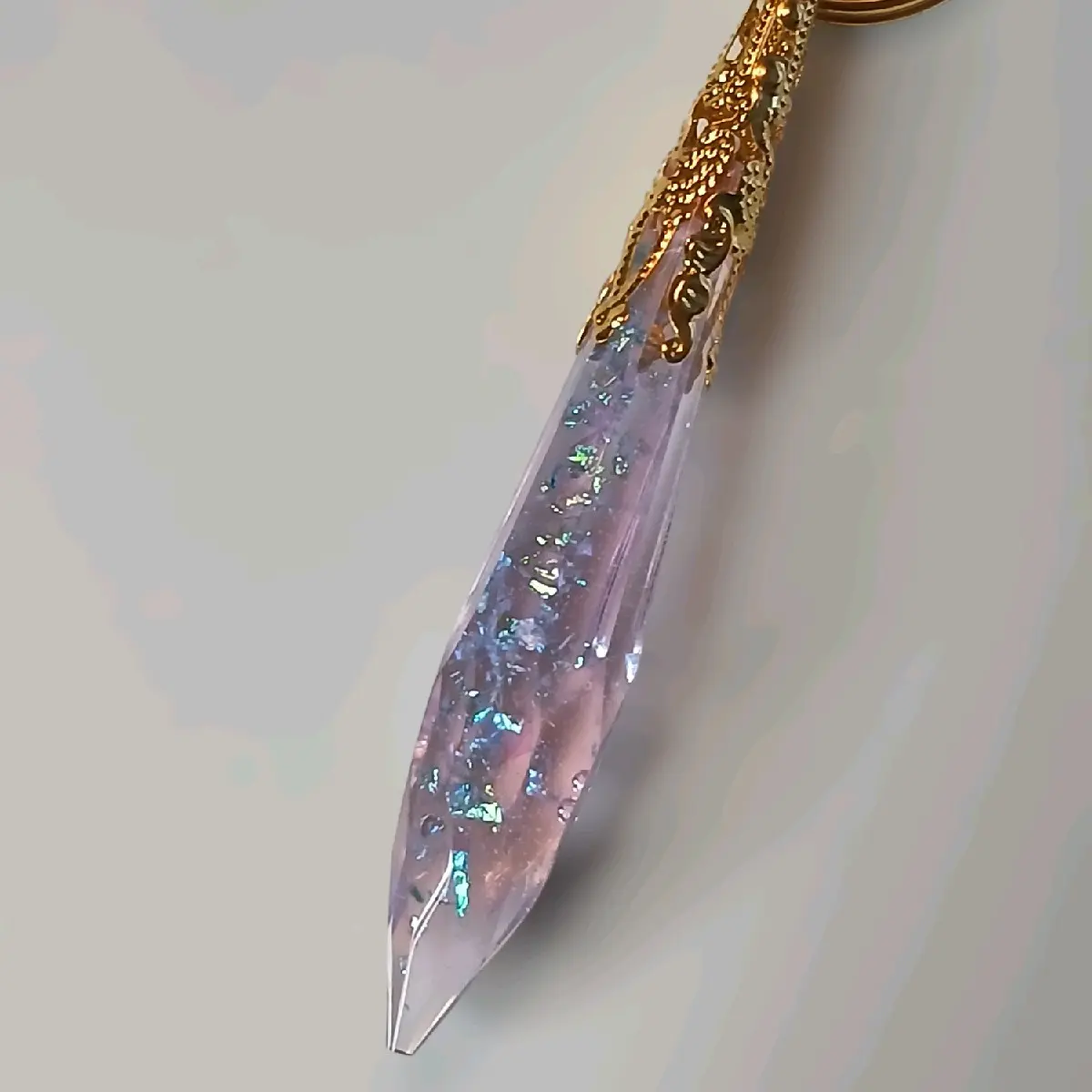 Pink Iridescent Resin Crystal Keychain Encapsulated In A Gold Colored Adornment.