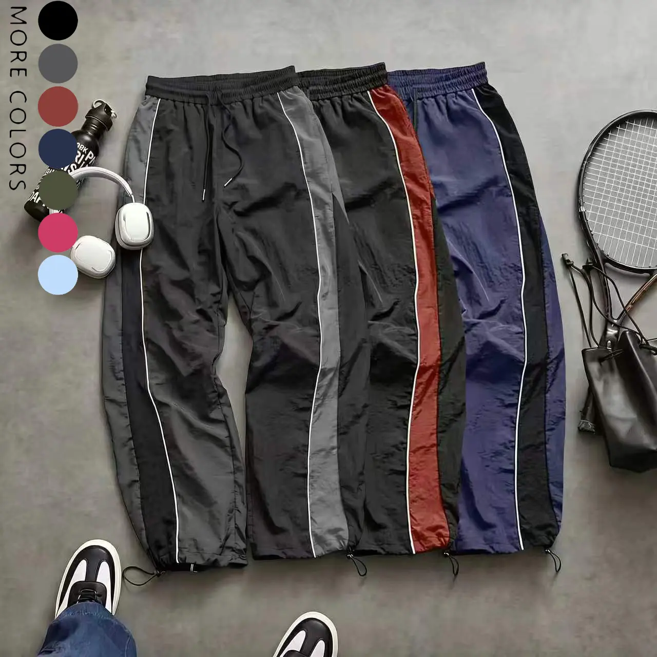 Men’s high-street style wide-leg pants with contrast color panels, side stripes, and a drawstring; American retro loose, drapey athletic pants; available in multiple colors; slim casual pants suitable for spring and summer wear.