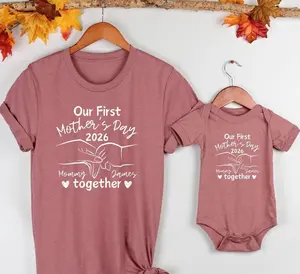 [Mother's Day Collection - Sale Up To 25%] Our First Mother's Day 2026 Shirt, Custom Name Mommy Graphic Tee, New Mom Celebration T-Shirt, Motherhood Keepsake Apparel, Cute Family Gift