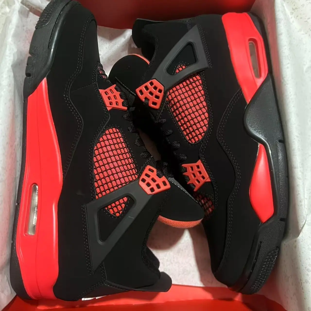 High‑Top Lace‑Up Basketball Sneakers, bold black and bright red color scheme, soft suede upper, red grid mesh side panels, red accent midsole, visible air cushion for sports and street‑wear daily outfits