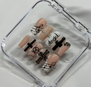 Bold nude and black nail art with crosses, musical notes, and edgy details, blending gothic vibes with a touch of glam for a striking, unique look