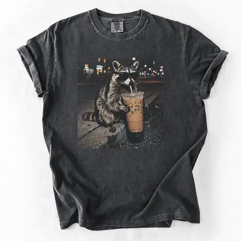 Three Raccoons Drinking Iced Coffee Comfort Colors T-Shirt with a funny Gen Z dank meme vibe, trendy cotton streetwear top and playful graphic gift for men and women alike.