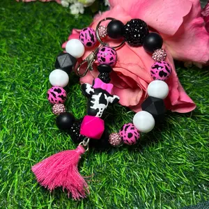 Moooody cow wristlet keychain color scheme black, white, cow print and bling beads made with wire