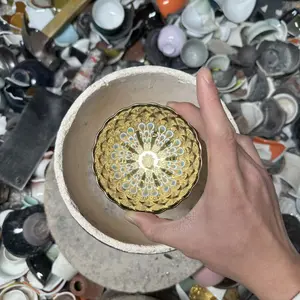 Handmade Jianzhan teacup, with a golden glaze, unique design, and hand-painted blue peacock feathers.