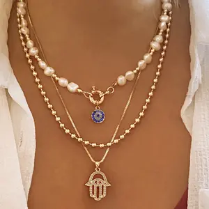 Bohemian Layered Pearl and Gold Hamsa Hand Necklace Evil Eye and Hamsa Hand Pendant for a Stylish Look