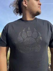 Walk with strength  This bear paw design represents protection, power, and presence — made to stand strong and shine  Handmade rhinestone design on a soft black tee  Available now.