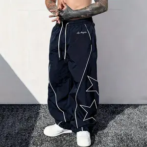 Men’s star print wide-leg athletic pants made from lightweight, breathable nylon fabric, featuring an elastic drawstring waist and contrasting piping; a versatile choice for Y2K street style, skateboarding, everyday wear, and summer outfits.