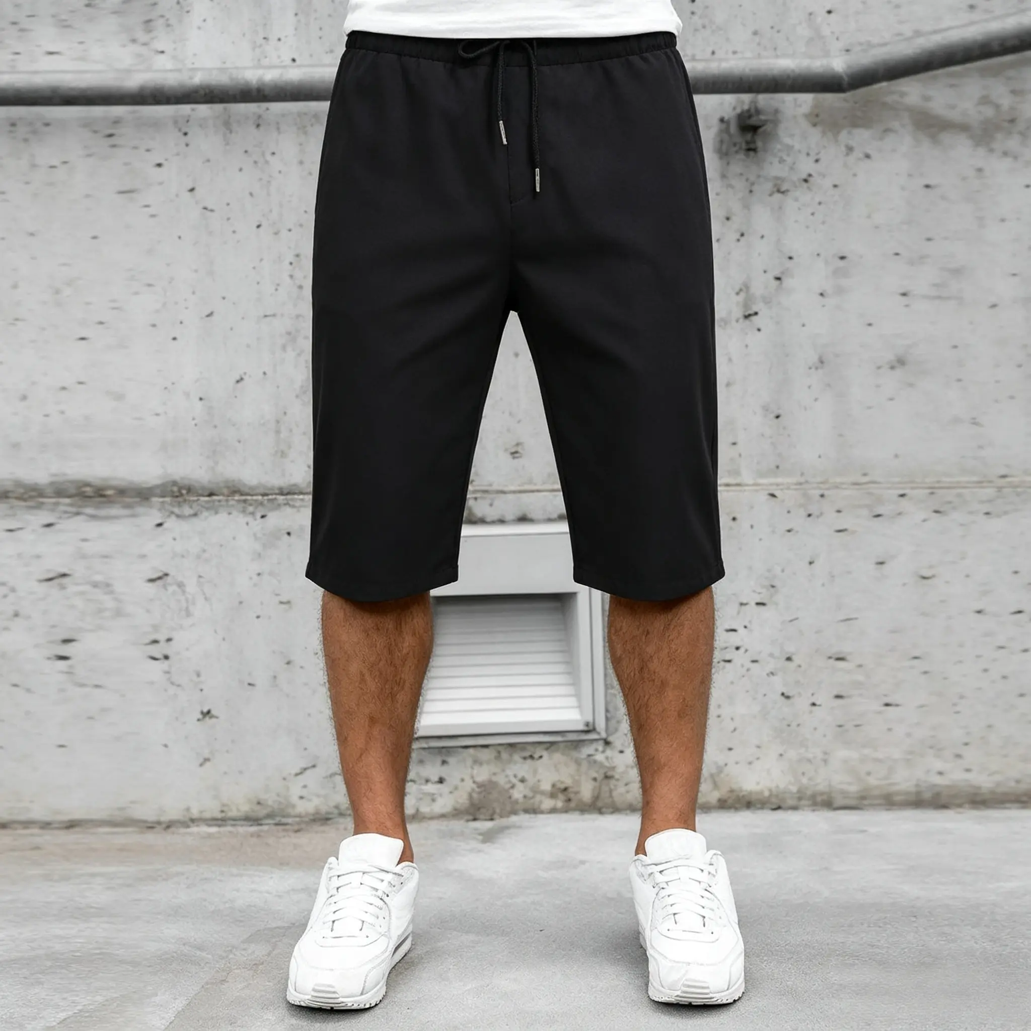 Solid-color three-quarter casual shorts with an elastic waistband and drawstring; a relaxed, mature style suitable for commuting; non-creasing, fluid fabric with a matte finish; understated black tones; flat waistband that resists rolling and deformation;