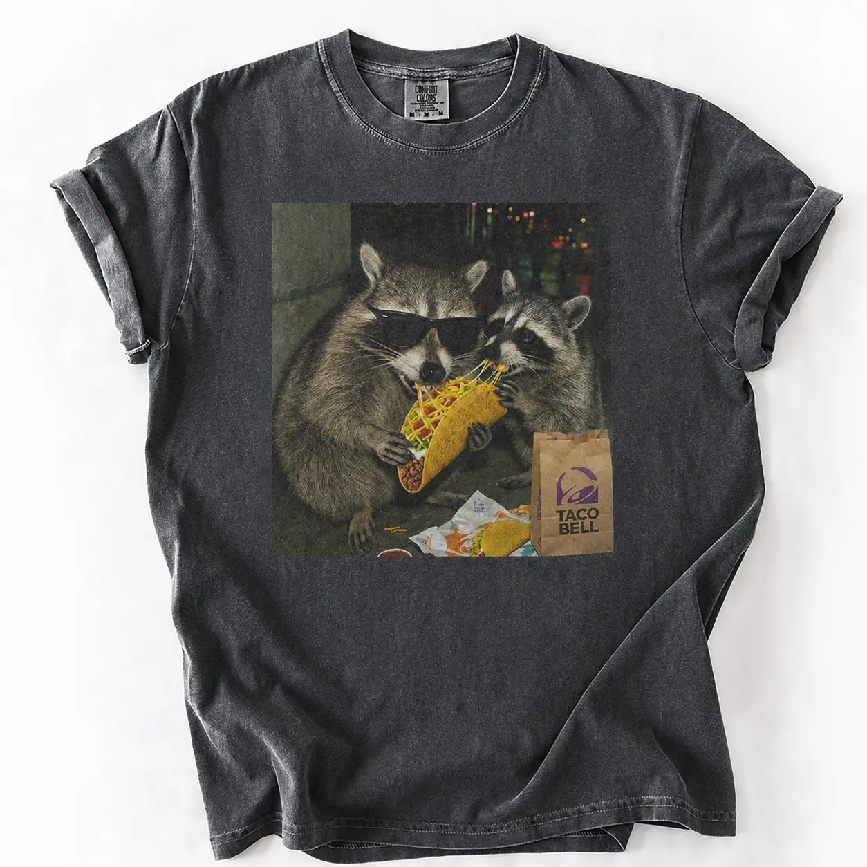 Comfort Colors Raccoon Eating Taco T-Shirt featuring a funny meme graphic, silly animal humor design, vintage retro unisex cotton top and cute gift for men and women alike.