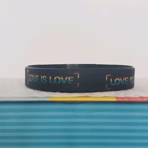 LGBTQIA+ PRIDE Silicone Wristband showing "LOVE IS LOVE" all around the band. Rainbow letters over a black band. Our original and discontinued line, adopt yours today before it's sold out. = )