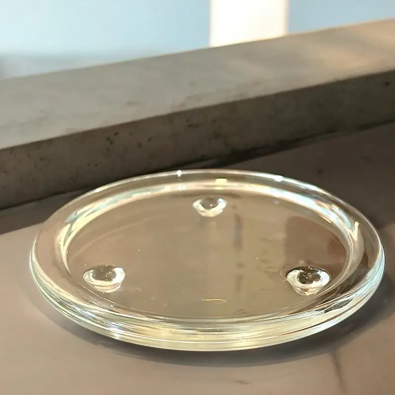 Clear glass candle plate with a tri-knob bottom for stability. Displaying your candle beautifully and elegantly on any tabletop enhancing your homes decor.