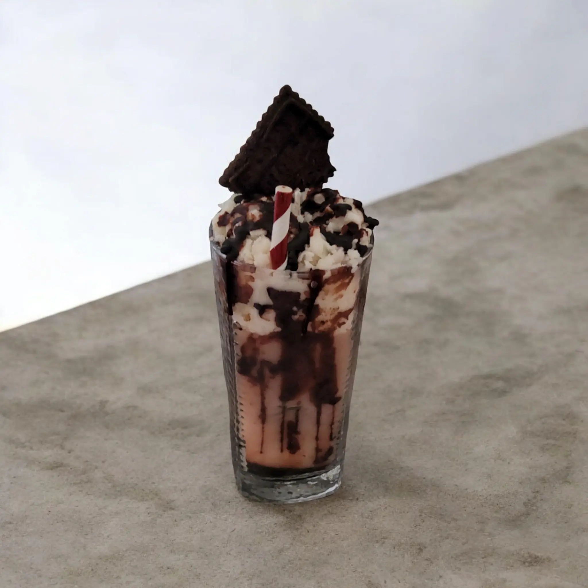 Chocolate whipped cream milkshake with chocolate cookie candle