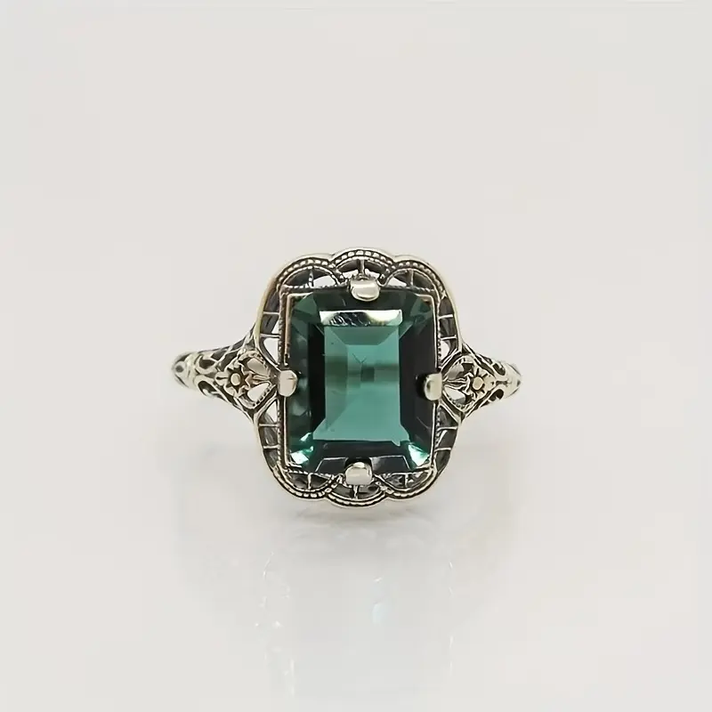This Victorian-inspired synthetic emerald ring features an openwork lace-patterned design that recreates the jewelry craftsmanship of the vintage era, making it an elegant, slightly luxurious antique-style ring for women.
