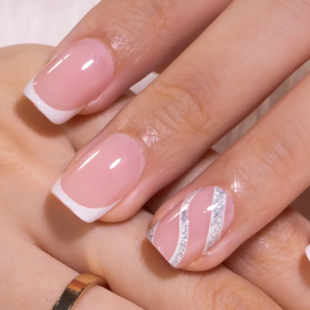 An elegant short square French manicure featuring soft nude pink nails with crisp white tips, paired with a delicate silver and white swirl accent design on the ring finger, creating a timeless and sophisticated look perfect for any occasion.