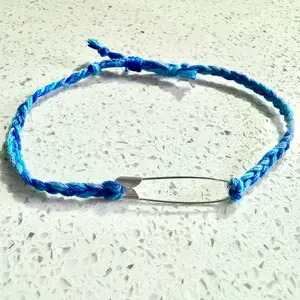 Blue friendship bracelet with safety pin