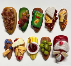 Charcuterie board nails — a deliciously detailed 3D design featuring miniature grapes, cheeses, olives, crackers, almonds, jam, and even a tiny “Club” box, recreating the ultimate snack platter in glossy, hyper-realistic nail art form