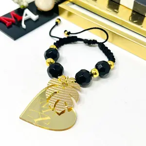 Black bracelet woven in adiustable macrame with gold laminated beads