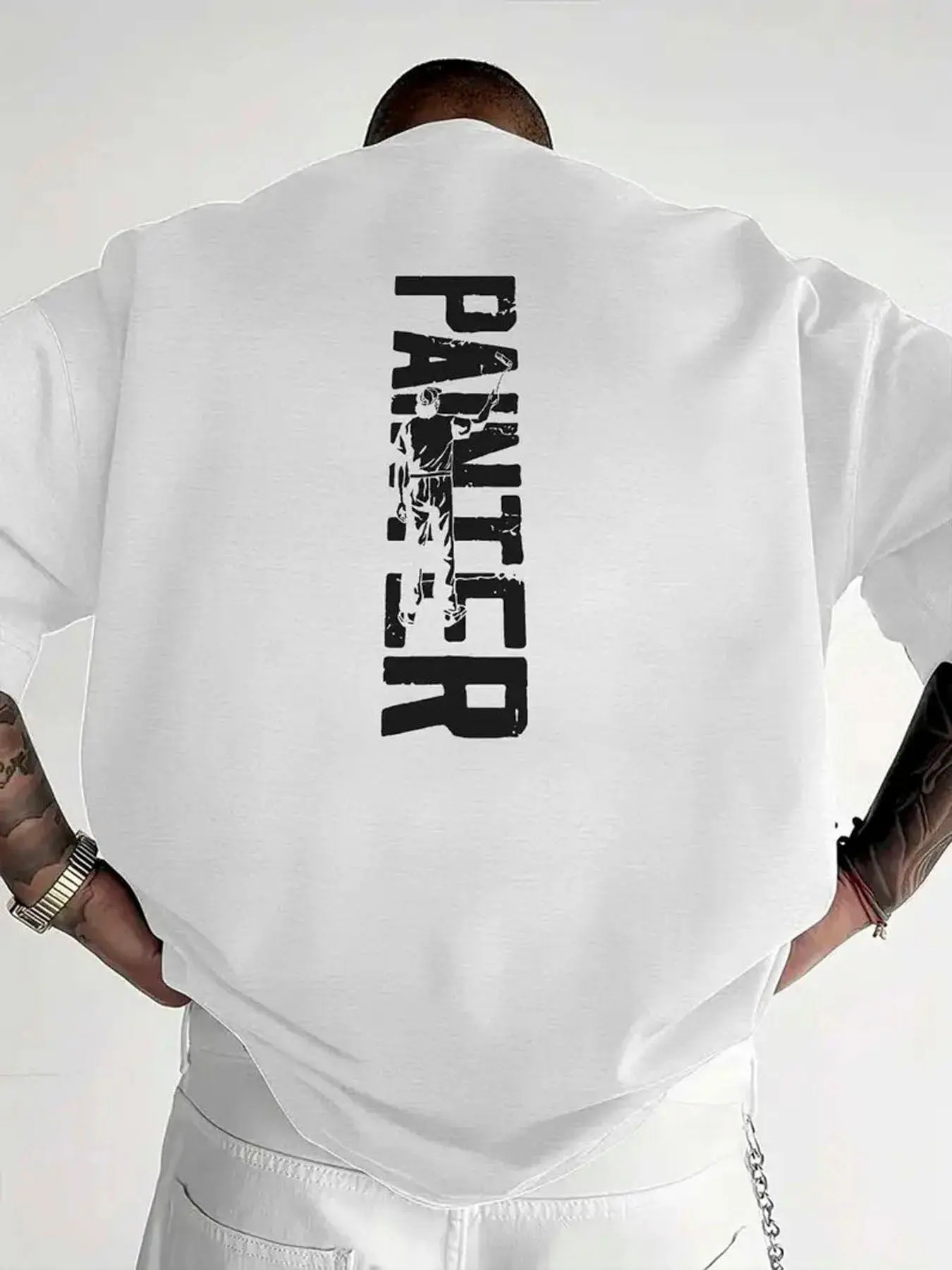 Shaved Head Painter Shirt - Black Long Sleeve Vertical White 'PAINTER' Printed T - shirt with Stylized Letters & Painter Figure on Back Tattooed Arms Silvery Watch White Pants with Chain Detail Pocket - Casual Fashion T - shirt for Art Lovers