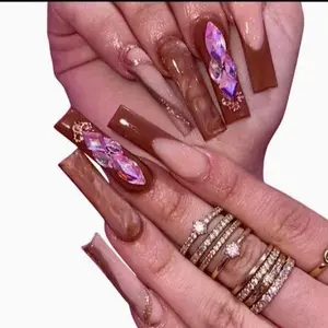 Elegant Brown Nail Art with Purple Crystal Accents and Gold Trim for a Luxurious Look