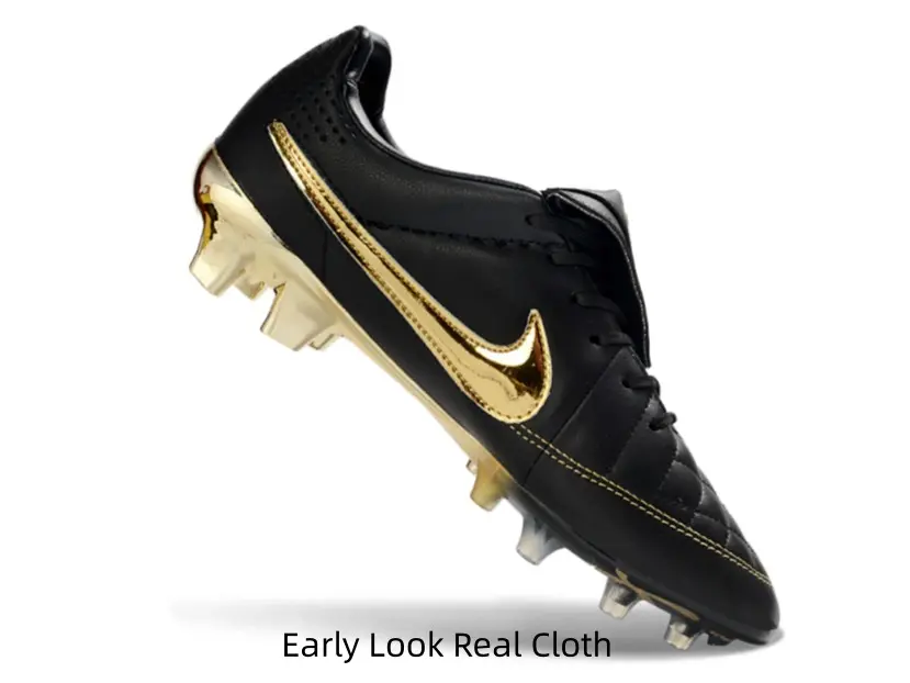 Sleek black soccer cleats with shiny metallic gold accents, premium pro match style