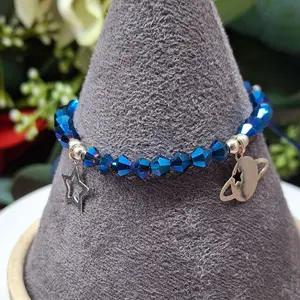 pulsera tejida en hilo color azul con charms de jupiter y estrella