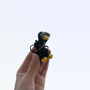 Bold all-black duck with a gold chain on a swing car decoration ornament