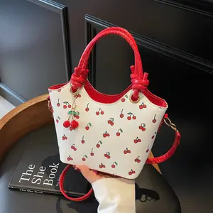 Women’s cherry print handbag, stylish commuter crossbody bag with adjustable shoulder strap; fashionable crossbody and handheld design; leather minimalist printed bag with cherry keychain included.