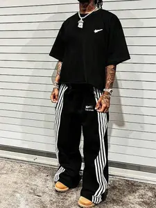 This men's two-piece set, Striped Lounge Set, includes a star-patterned T-shirt and trousers featuring lettering and a star design. Made from a knit fabric, it's suitable for everyday wear and can be worn year-round. Casual Streetwear Set