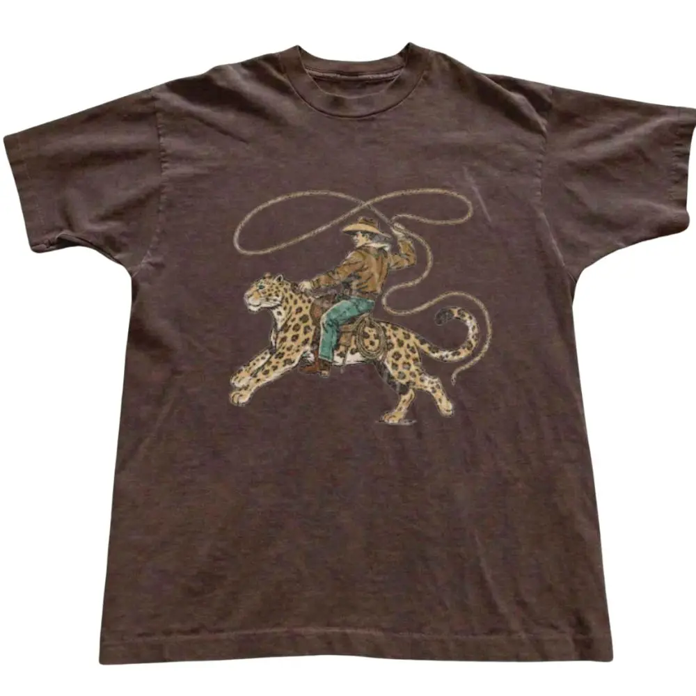 The Cowboy Riding Leopard Graphic T-Shirt, Western Animal Art Tee, Vintage Rodeo Aesthetic Shirt, Unisex Brown Top, Unisex Streetwear Top, Gift For Woman, Gift For Men, Womenswear Top Underwear Streetwear, Trending Shirt