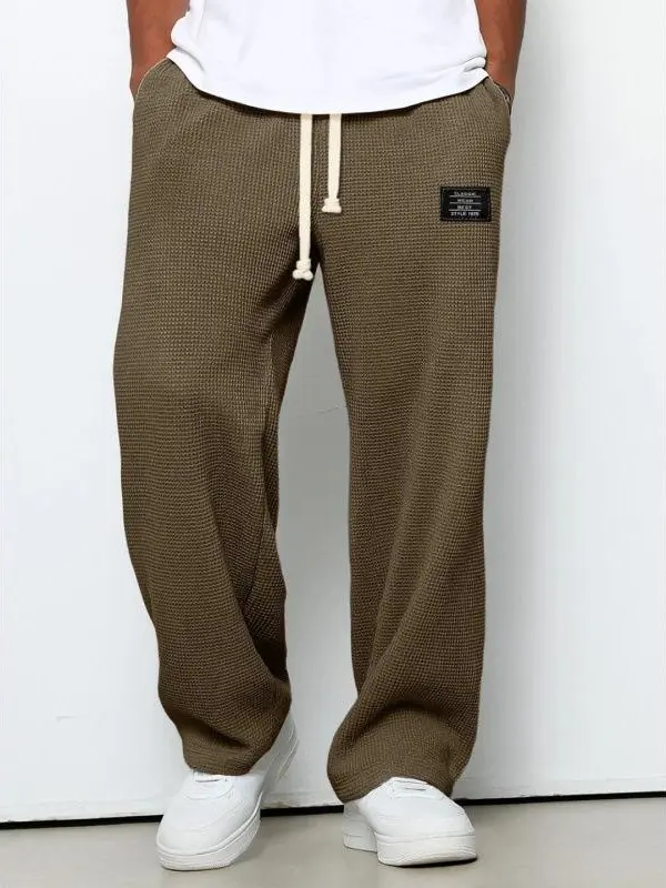 Men’s casual pants, waffle-knit wide-leg sweatpants, 100% polyester fiber, elastic drawstring waist, decorative label, loose fit, street athletic style long pants, soft and breathable, suitable for fitness training, home wear, travel, and everyday outdoor