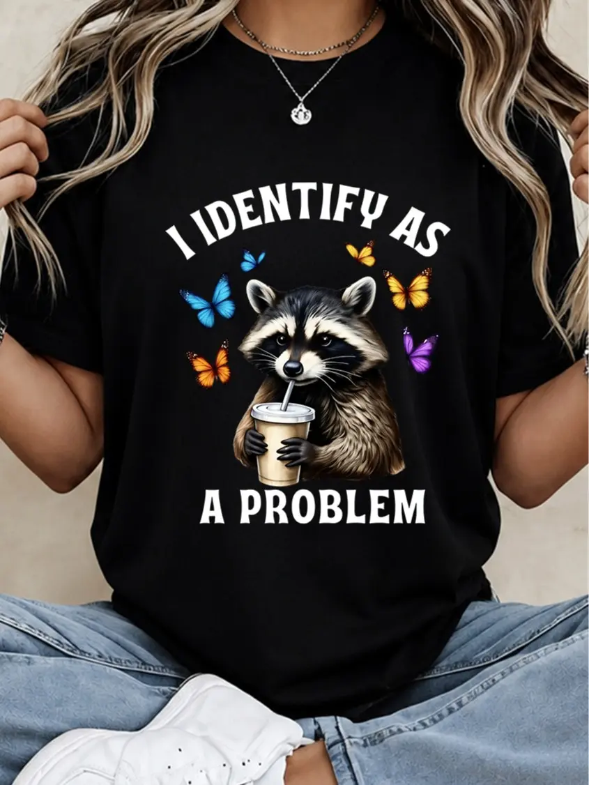 I Identify As A Problem Funny Raccoon Drinking Coffee Graphic Men And Women Cotton Crew Neck T-Shirt Sarcastic Humor Trash Panda With Butterflies Design For Quirky Summer Fits And Casual Loungewear