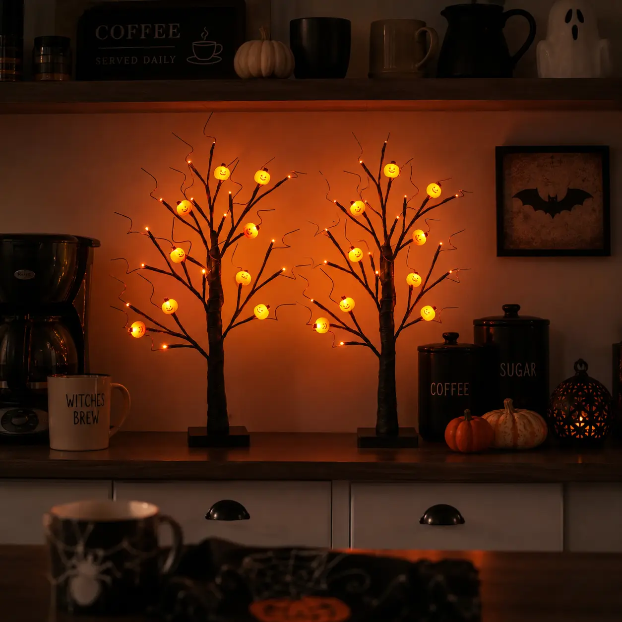 Set of 2 Halloween tabletop tree lights (approx. 2 ft tall); features artificial black branches with flexible twigs and small pumpkins. Battery-operated; ideal for Halloween and autumn harvest decor on patios, mantels, dining tables, entryways, and more.
